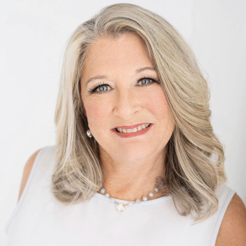 Donna Melton, Gulf Coast Mississippi realtor, smiling woman with open hair wearing a white dress